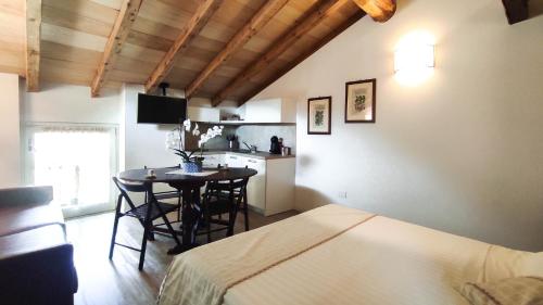 a bedroom with a bed and a table and a kitchen at B&B ai Musei in Brescia
