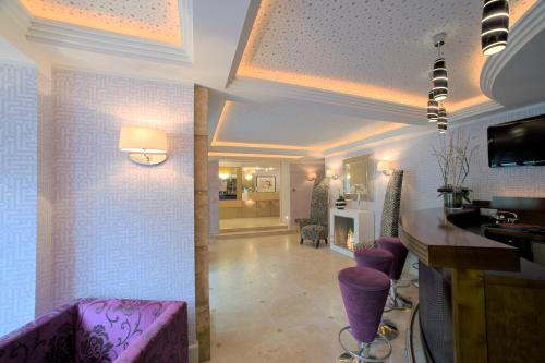 a living room with purple stools and a bar at Top Hotel Krämer in Koblenz