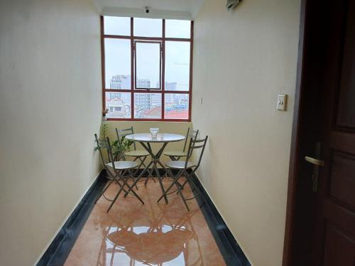 a table and chairs in a room with a window at Spean Meas Hotel in Phnom Penh