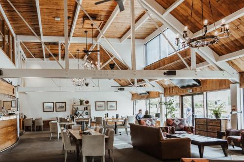 a restaurant with wooden ceilings and tables and chairs at Edgewater Hotel in Wanaka