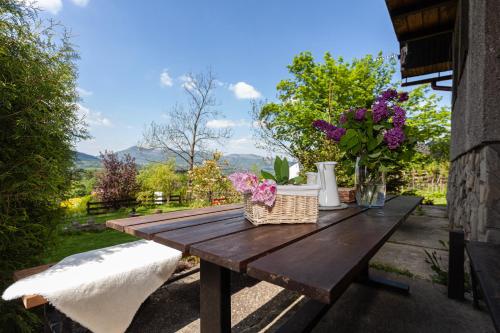 a wooden picnic table with flowers on a patio at Tři smrčky in Ostravice