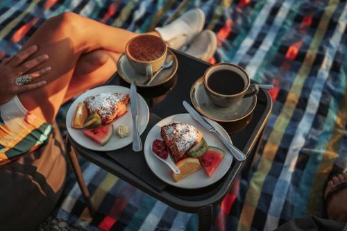 a table with two plates of food and two cups of coffee at Edgewater Hotel in Wanaka