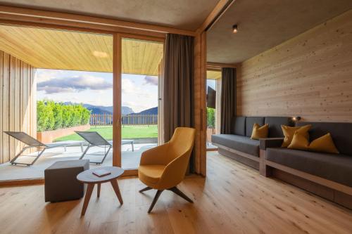 a living room with a couch and a table at Tratterhof Mountain Sky Hotel in Maranza