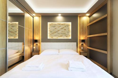 a bedroom with a large white bed and mirrors at SCANDIC Apartments Boží Dar in Boží Dar