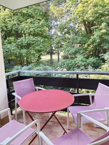 a red table and chairs on a porch with a table at Happy family's nest in Munster