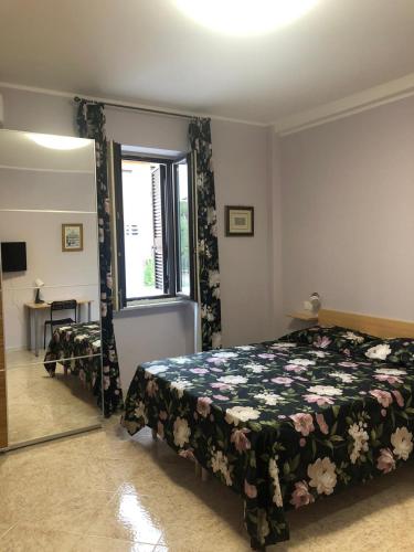 una camera con letto, finestra e specchio di B&B Antonella a Monterotondo