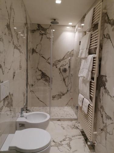 a bathroom with a shower and a toilet and a sink at Asisium Boutique Hotel in Assisi