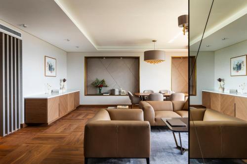 a living room with a couch and a table at Grand Hotel Millennium Sofia in Sofia