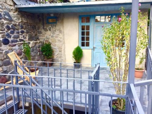a house with a blue door and some plants at sweet home in Borjomi