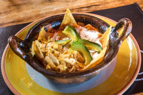 a bowl of food sitting on a yellow plate at Hotel Pozo Viejo in Zacapoaxtla