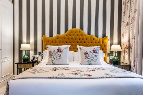 a bedroom with a bed and two tables with lamps at Hotel Casa Palacio María Luisa in Jerez de la Frontera