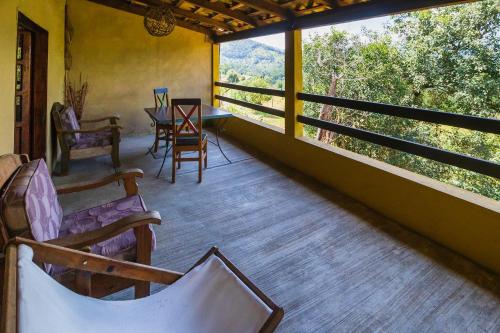 a porch of a house with chairs and a table at Hotel Pozo Viejo in Zacapoaxtla