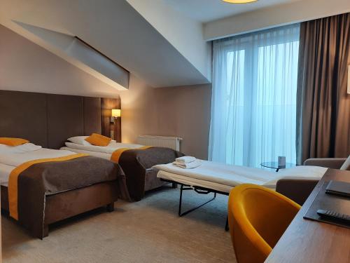 um quarto de hotel com duas camas e uma janela em Hotel Imperiale em Oświecim