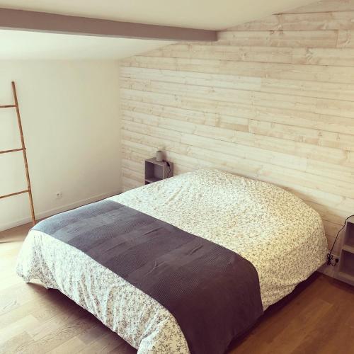 une chambre avec un lit avec un mur de briques dans l'établissement Nono’s Cocoon House, à Bergerac