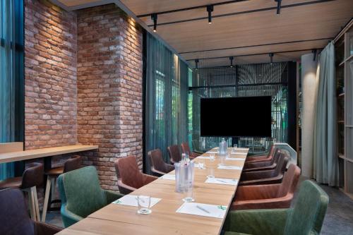 a conference room with a long table and a flat screen tv at Holiday Inn - Osnabrück by IHG in Osnabrück