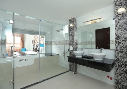 a bathroom with two sinks and a glass shower at The Mira Boutique Hotel in Thu Dau Mot