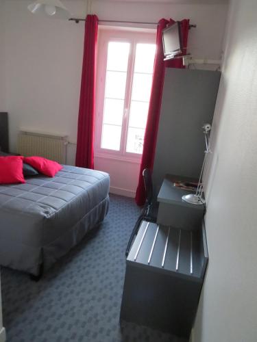 a bedroom with a bed and a window with red curtains at Hôtel de Clèves in Nevers