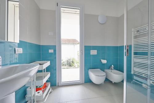 baño azul y blanco con lavabo y aseo en Casa Mia Lake Como, en Mandello del Lario