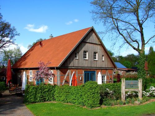 uma grande casa castanha com um telhado vermelho em DZ/EZ Lodberger Scheunencafe em Löningen