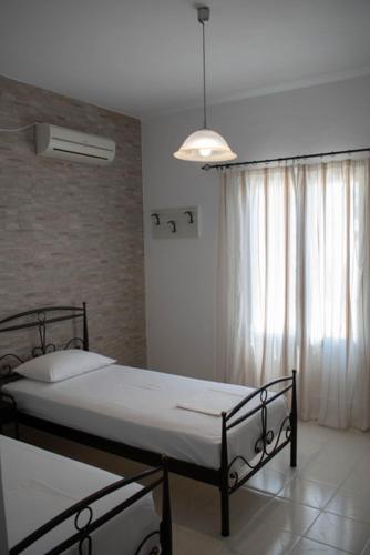 a bedroom with two beds and a window at Kouki Maria Rooms in Apollonia
