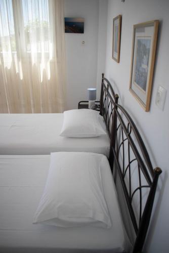 a bedroom with two beds and a window at Kouki Maria Rooms in Apollonia