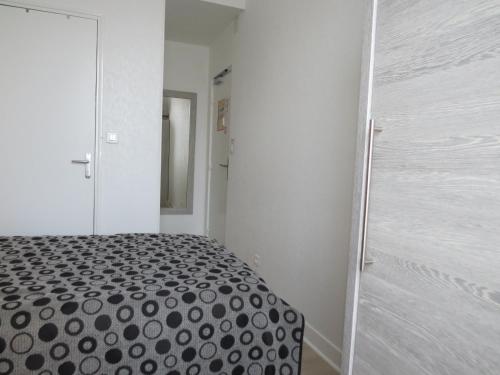 a white room with a bed and a closet at Hôtel de Clèves in Nevers