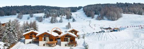 a ski lodge on a snow covered slope with a ski lift at Chalet HERRISSON Peisey- Vallandry - Domaine Paradiski in Peisey-Nancroix