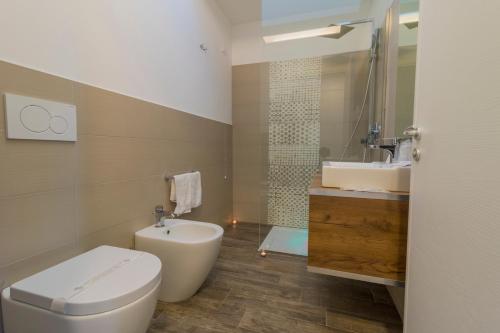 ein Bad mit einem WC und einem Waschbecken in der Unterkunft Villaggio Poseidone Beach Resort - Hotel in Torre San Giovanni Ugento