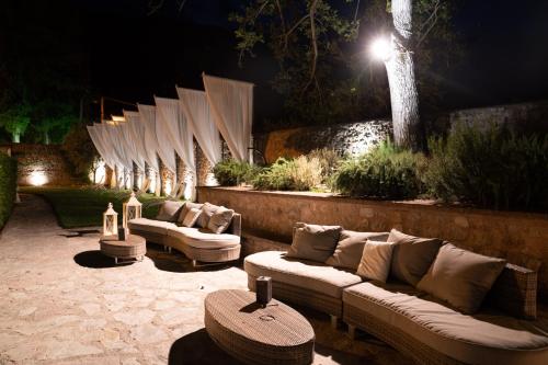 a row of couches sitting on a patio at night at Ex Convento Santa Croce-Country resort in SantʼAnatolia di Narco