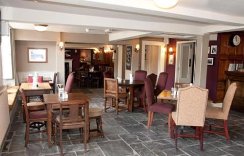 comedor con mesas y sillas de madera en Woolpack Inn by Greene King Inns, en Frome