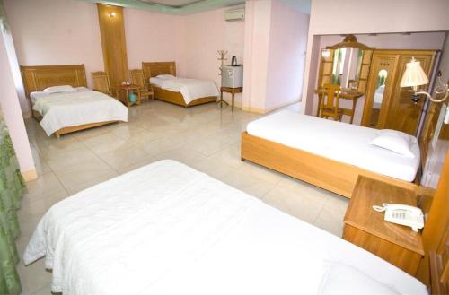 a hotel room with two beds and a mirror at Thành Mỹ Hotel in Cam Ranh