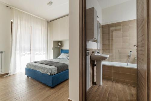 a bedroom with a bed and a sink and a tub at Fonte Laurentina Apartments in Rome
