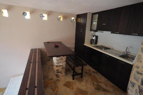 a small kitchen with a wooden table and a sink at ΕΥμορφο σαν παραμύθι ΑΜΥΓΔΑΛΙΑ in Amfiklia
