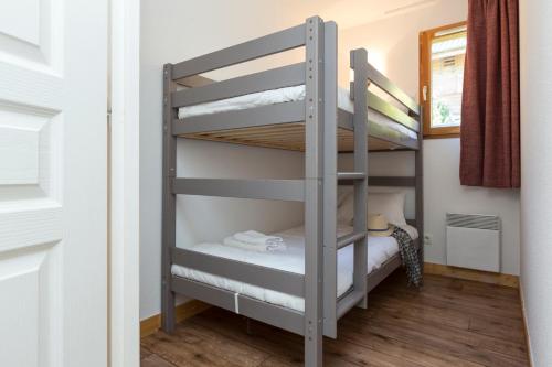 Un pat sau paturi într-o cameră la Résidence Odalys Les Chalets de l'Arvan II