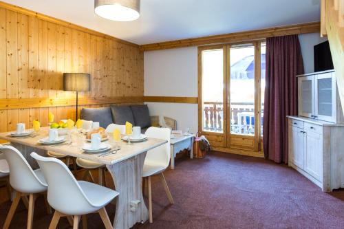 une salle à manger avec une table et des chaises dans l'établissement Résidence Odalys Les Chalets de l'Arvan II, à Saint-Sorlin-dʼArves
