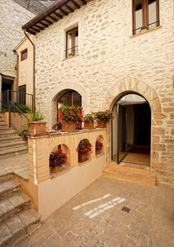 a building with potted plants on the side of it at Hotel Sorella Luna in Assisi