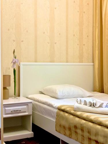 a bedroom with two beds and a table with a night stand at Sergeev Hotel in Mykolaiv