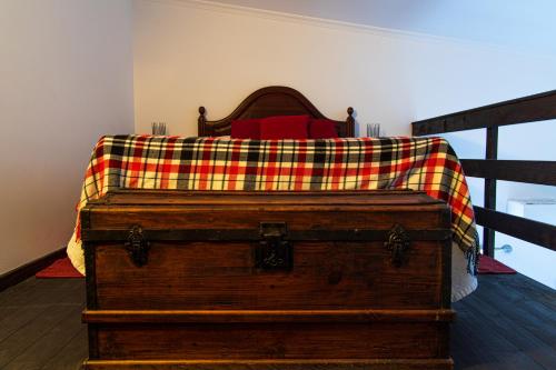 a wooden trunk with a plaid blanket on top of it at Refugio no Campo - AL 1683 in Rapoula do Côa
