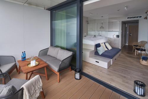 Cette chambre comprend un lit, un canapé et une table. dans l'établissement Seaside Park Apartament Prywatny 405 z widokiem na morze, à Kołobrzeg