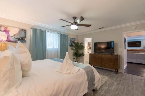 een slaapkamer met een wit bed en een flatscreen-tv bij Private Pool 3BR all new Modern Furniture in Hollywood