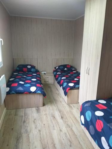 twee bedden in een kamer met twee bedden sidx sidx sidx bij Domek Dwupokojowy N4 - FreezerHause Kozery- NoclegiGrodziskPL 792-535-535 in Grodzisk Mazowiecki