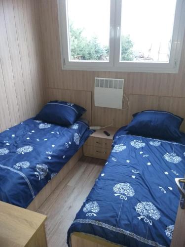 1 dormitorio con 2 camas y 2 ventanas en Domek Dwupokojowy N4 - FreezerHause Kozery- NoclegiGrodziskPL 792-535-535, en Grodzisk Mazowiecki
