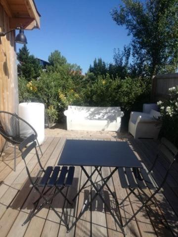 a patio with two chairs and a table on a deck at La cabane poetique in La Teste-de-Buch