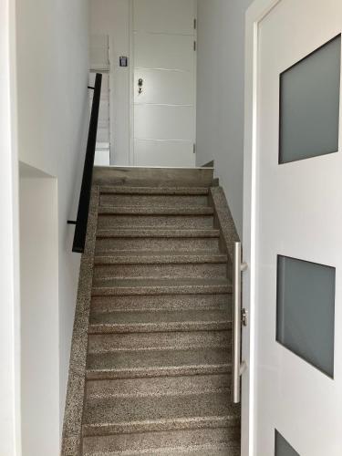 a hallway with a stairway with two television at Les Duplex de la Place des Ecoles in Spa