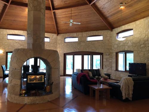 a living room with a stone fireplace in a house at Harmony Forest Cottages & Lake side Lodge in Margaret River Town
