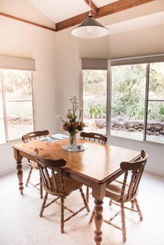 a dining room with a wooden table and chairs at Harmony Forest Cottages & Lake side Lodge in Forest Grove
