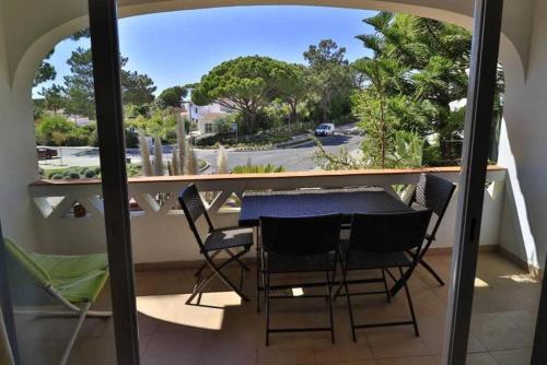 uma varanda com uma mesa e cadeiras e vista para uma rua em Casa Vale Do Lobo 832A - Charming Townhouse AC few minutes walk from Beach Praca no Vale do Lobo