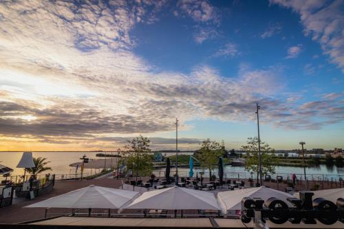 a group of tables and white tents next to the water at Hotel Bella Ciao in Harderwijk
