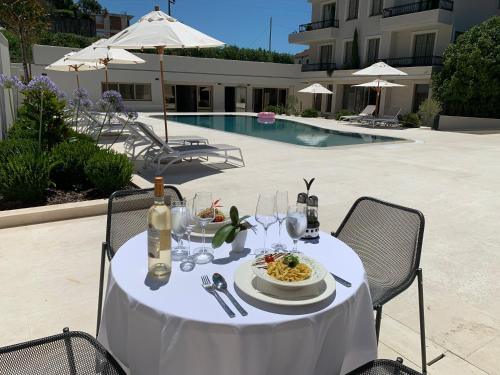 a white table with a plate of food and wine at Avanti Hotel & Spa in Budva