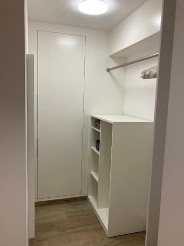 a walk in closet with white walls and shelves at Les Duplex de la Place des Ecoles in Spa